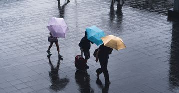 Menschen mit Schirm im Regen