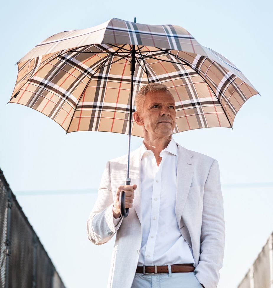 Mann mit kariertem Swissmade Regenschirm